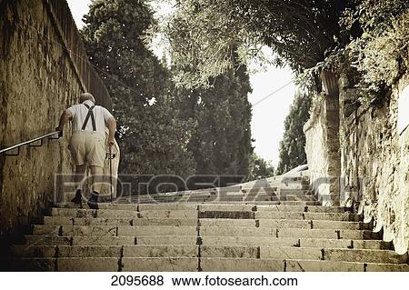 Stock Photo - A Senior Man Walks Up Steps; Cannes Provence France. Fotosearch