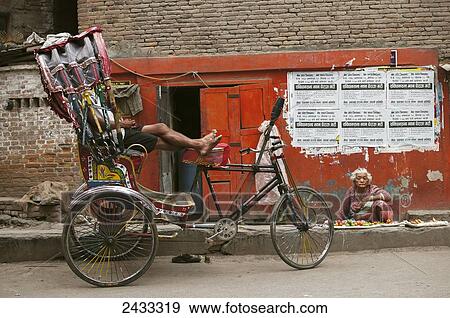 A senior woman selling vegetables on the ground, a rickshaw driver resting in his vehicle in a typical Kathmandu's street; Kathmandu, Nepal View Large Photo Image Stock Photo - A senior woman selling vegetables on the ground, a rickshaw driver resting in his vehicle in a typical Kathmandu's street; Kathmandu, Nepal. Fotosearch
