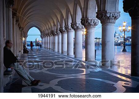 Stock Image - A Sheltered Promenade With Columns On A Rainy Evening; Venice Venezia Italy. Fotosearch