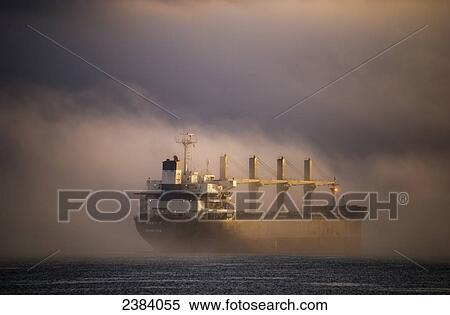 Stock Photography - A ship anchors in the fog on the Columbia River; Astoria, Oregon, United States of America. Fotosearch