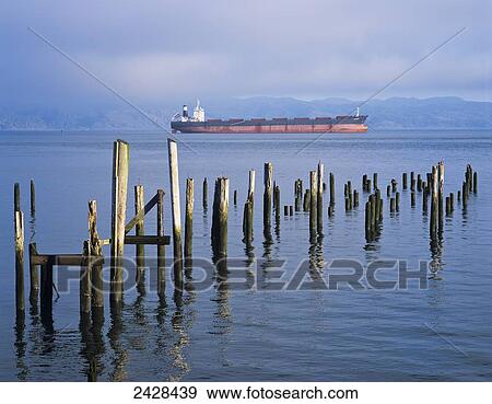 Stock Photo - A ship anchors near Astoria with pilings in the water; Oregon, United States of America. Fotosearch