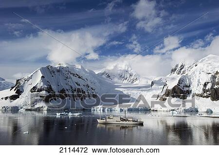Stock Image - A Ship Sailing Along The Coastline; Antarctica. Fotosearch