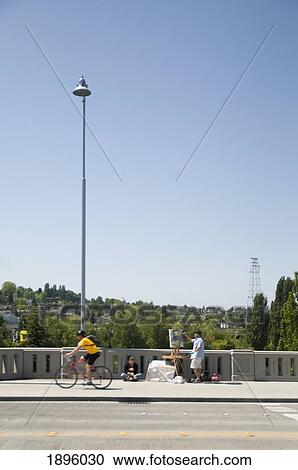 A Sidewalk Painter Painting On Canvas While A Cyclist Rides By; Seattle, Washington, United States Of America View Large Photo Image Stock Image - A Sidewalk Painter Painting On Canvas While A Cyclist Rides By; Seattle, Washington, United States Of America. Fotosearch