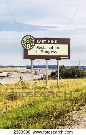 Stock Photograph - A sign at Syncrude points to future redevelopment and environmental land reclamation of the completed mining area in the oil sands; Fort McMurray, Alberta, Canada. Fotosearch