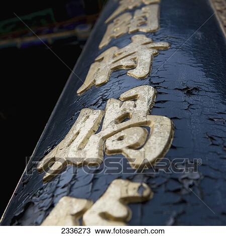 Stock Image - A Sign On A Post With Peeling Paint; Beijing, China. Fotosearch