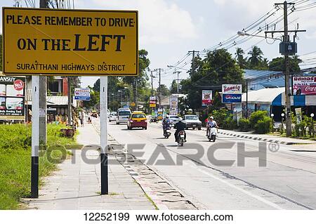 Stock Photo - A sign warning foreigners to drive on the left hand side of the road; Ko Samui, Thailand. Fotosearch