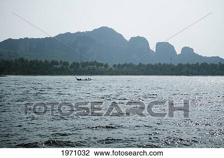 Stock Image - A Small Boat In The Water Off Tonsai Beach; Phi Phi Islands Thailand. Fotosearch