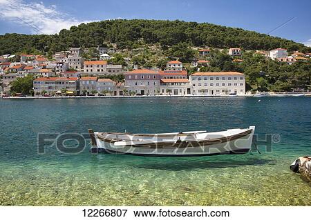 A small boat rests in the tranquil clear water; Pucisca, Island of Brac, Croatia View Large Photo Image Stock Photo - A small boat rests in the tranquil clear water; Pucisca, Island of Brac, Croatia. Fotosearch