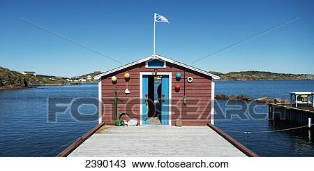 A small building at the end of a pier with the flag of Newfoundland and Labrador; Twillingate, Newfoundland and Labrador, Canada View Large Photo Image Stock Image - A small building at the end of a pier with the flag of Newfoundland and Labrador; Twillingate, Newfoundland and Labrador, Canada. Fotosearch