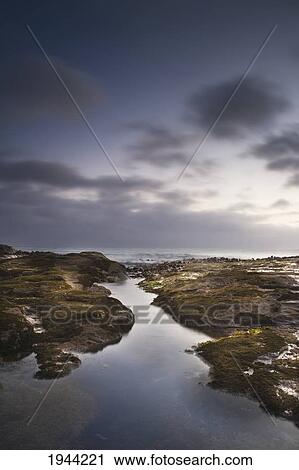 Stock Image - A Small Waterway Leading In From The Ocean; Curio Bay South Island New Zealand. Fotosearch