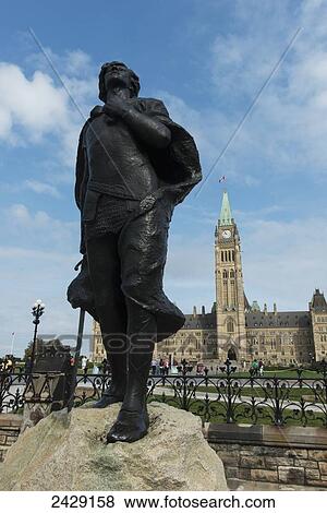Stock Photo - A statue in the foreground with Peace Tower on Parliament Hill in the background; Ottawa, Ontario, Canada. Fotosearch