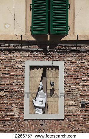 A statue in the window of a brick building, looking out past the curtains; Montepulciano, Tuscany, Italy View Large Photo Image Stock Photo - A statue in the window of a brick building, looking out past the curtains; Montepulciano, Tuscany, Italy. Fotosearch