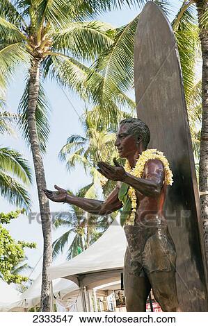 Stock Photo - A statue of a surfer wearing a floral lei; Honolulu, Oahu, Hawaii, United States of America. Fotosearch