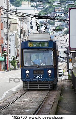 Stock Image - A Street Car Traveling On A Street; Nagasaki, Japan. Fotosearch