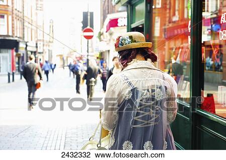 Stock Image - A stylish young woman walking in Carnaby Street; London, England. Fotosearch