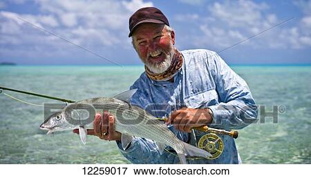 Stock Photo - A successful Bone Fisherman; Aitutaki, Cook Islands. Fotosearch