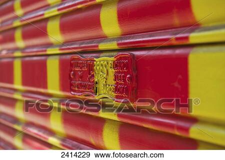 Stock Photo - A surface painted with red and yellow stripes and a small plaque on it; Barcelona, Spain. Fotosearch