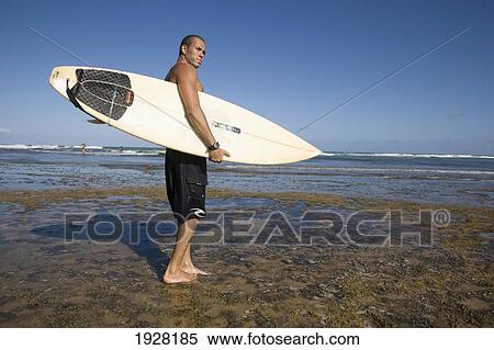 Stock Photography - A Surfer With His Surfboard At The Beach, Praia Do Forte, Bahia, Brazil. Fotosearch
