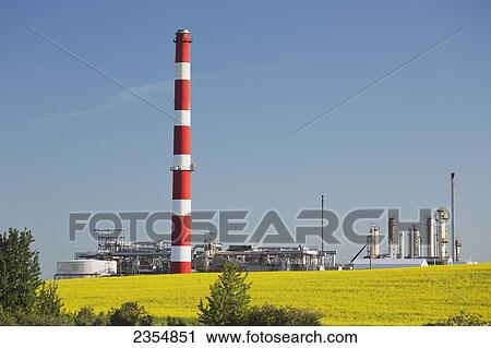 Stock Image - A Tall Tower At A Refinery Next To Farmland; Alberta, Canada. Fotosearch