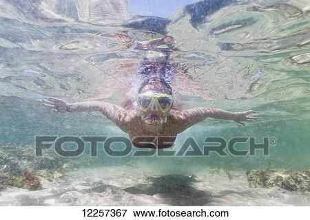 Stock Photo - A teenage girl swims underwater along the water's surface; Tarifa, Cadiz, Andalusia, Spain. Fotosearch