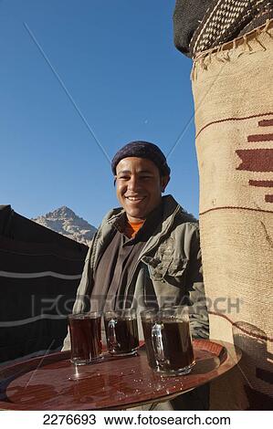 A tourist guide offers hot coffee at a Bedouin camp in the middle of the Wadi Rum desert; Jordan View Large Photo Image Stock Image - A tourist guide offers hot coffee at a Bedouin camp in the middle of the Wadi Rum desert; Jordan. Fotosearch