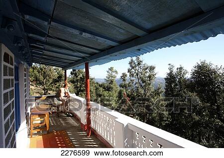 A tourist looks over the railing of a porch out to the Indian Himalayas; Utaranchal, India View Large Photo Image Stock Photo - A tourist looks over the railing of a porch out to the Indian Himalayas; Utaranchal, India. Fotosearch