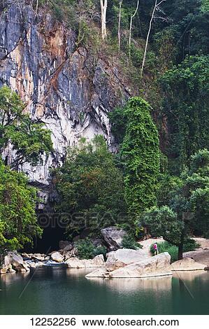 Stock Photograph - A tourist outside the Seven kilometre caves; Kong Lor, Laos. Fotosearch
