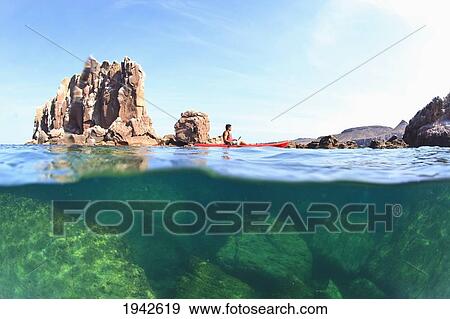 Stock Photo - A Tourist Paddles A Boat In Los Islotes National Marine Park By Espiritu Santo Island; La Paz Baja California Mexico. Fotosearch