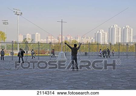 A Tourist Stands Posing For A Photograph With Arms Raised; Beijing China View Large Photo Image Picture - A Tourist Stands Posing For A Photograph With Arms Raised; Beijing China. Fotosearch