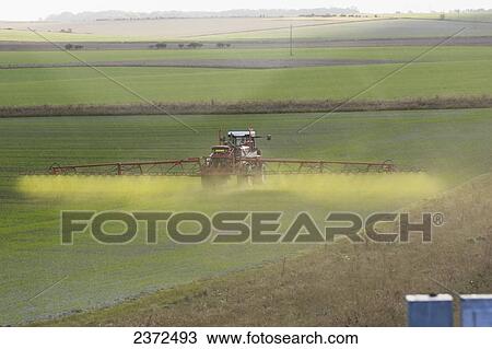 Stock Image - A tractor and crop sprayer on a farm field; United Kingdom. Fotosearch