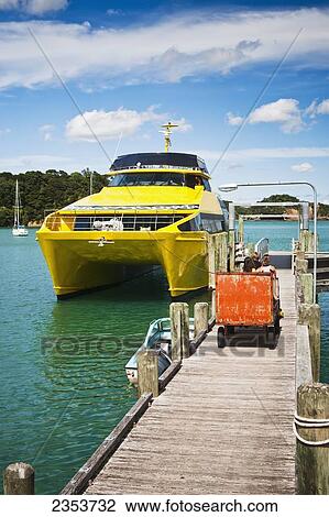 Stock Image - A Tractor Helps Bring Luggage Off A Boat To The Boat Terminal; Urupukapuka Island, New Zealand. Fotosearch
