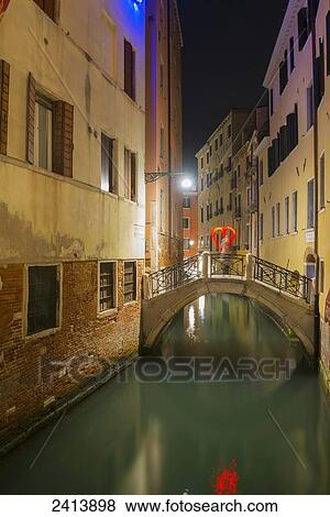A tranquil canal between buildings with a heart shape on a footbridge; Venice, Veneto, Italy View Large Photo Image Stock Photo - A tranquil canal between buildings with a heart shape on a footbridge; Venice, Veneto, Italy. Fotosearch