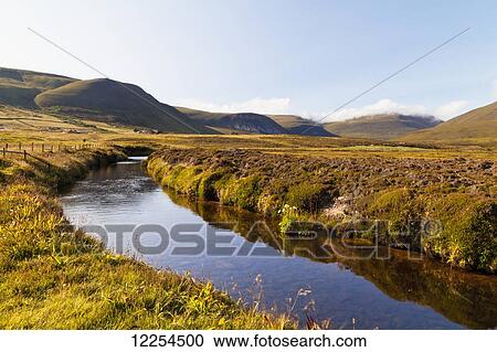 Stock Image - A tranquil stream runs through the hilly landscape; Rackwick, Orney, Scotland. Fotosearch