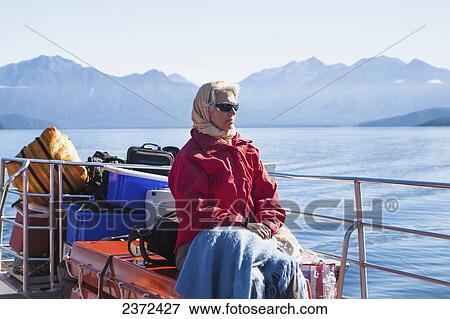 Stock Photo - A Traveler Enjoying A Scenic Boat Cruise On Lake Manapouri To Doubtful Sound; New Zealand. Fotosearch