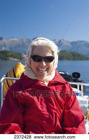 Stock Photo - A Traveler Enjoying A Scenic Boat Cruise On Lake Manapouri To Doubtful Sound; New Zealand. Fotosearch