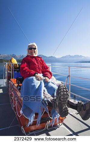 Stock Photo - A Traveler Enjoying A Scenic Boat Cruise On Lake Manapouri To Doubtful Sound; New Zealand. Fotosearch