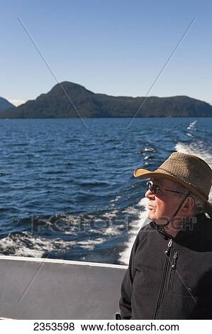 Stock Photo - A Traveler Enjoys A Ferry Ride Across Lake Manapouri In Doubtful Sound; Manapouri, New Zealand. Fotosearch