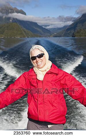 Stock Image - A Traveler Enjoys The Scenic Cruise Across Lake Manapouri To Doubtful Sound; New Zealand. Fotosearch