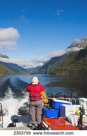 Stock Photo - A Traveler Enjoys The Scenic Cruise Across Lake Manapouri To Doubtful Sound; New Zealand. Fotosearch