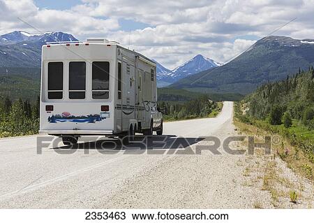 Stock Image - A Truck And Camper Heading North To Alaska On The Alaska Highway Near Rancheria; Yukon, Canada. Fotosearch