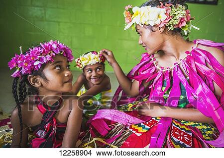 Picture - A Tuvalu woman with two young girls dressed in traditional costume; Tuvalu. Fotosearch