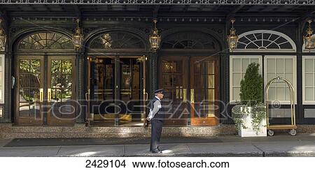 Picture - A valet stands outside the entrance of a hotel; Montreal, Quebec, Canada. Fotosearch