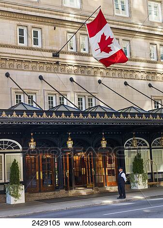 A valet stands outside the entrance of a hotel with a Canada flag flying overhead; Montreal, Quebec, Canada View Large Photo Image Stock Photography - A valet stands outside the entrance of a hotel with a Canada flag flying overhead; Montreal, Quebec, Canada. Fotosearch
