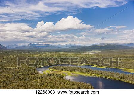 Stock Image - A view of the Baird Mountains and tundra covered hills and forest, Kobuk River, Arctic Alaska, summer. Fotosearch