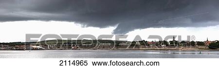 Stock Photography - A Village Along The Coast Under Dark Clouds; Whitley Bay Northumberland England. Fotosearch