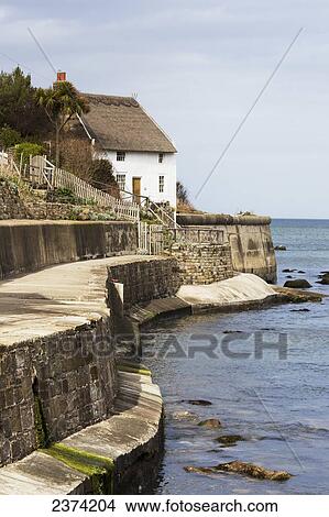 Picture - A wall, house and promenade along the water's edge; Runswick Bay, North Yorkshire, England. Fotosearch
