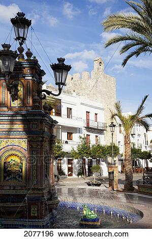 Stock Photograph - A Water Fountain And Palm Trees In The Town; Vejer De La Frontera Andalusia Spain. Fotosearch