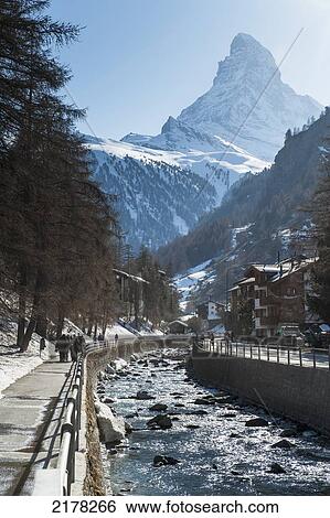 A Waterway Running Through The City With Pedestrians Walking On The Promenade; Zermatt Switzerland View Large Photo Image Stock Photograph - A Waterway Running Through The City With Pedestrians Walking On The Promenade; Zermatt Switzerland. Fotosearch
