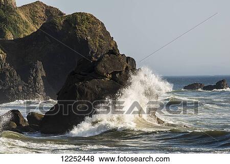 Stock Photo - A wave breaks on the rocks; Cannon Beach, Oregon, United States of America. Fotosearch