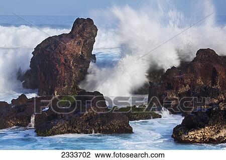 Stock Image - A wave crashes onto lava; Hookipa, Maui, Hawaii, United States of America. Fotosearch